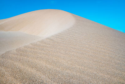 Sand dunes against clear sky