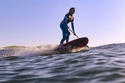 Full length of man in sea against clear sky