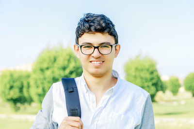 Portrait of smiling man wearing eyeglasses against sky
