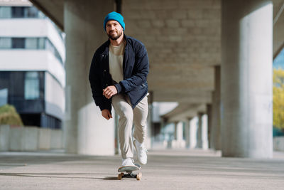 Young man skateboarding on footpath