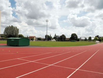 Empty benches on field against sky