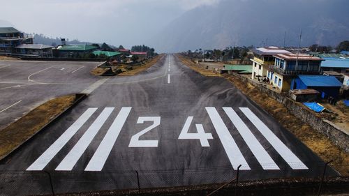 Text on road against sky in city