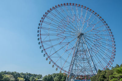 Low angle view of ferris wheel against clear blue sky