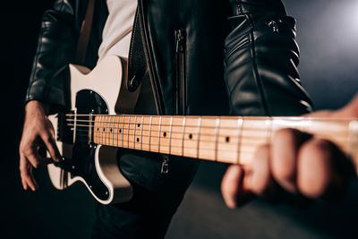 Midsection of man playing guitar