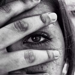 Close-up of woman covering face with hand