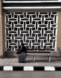 Woman sitting on sidewalk