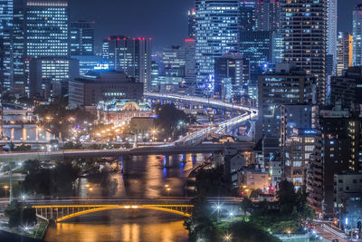 Illuminated buildings and bridge in city