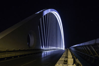 Illuminated bridge against sky at night