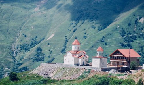 Houses by mountain against sky
