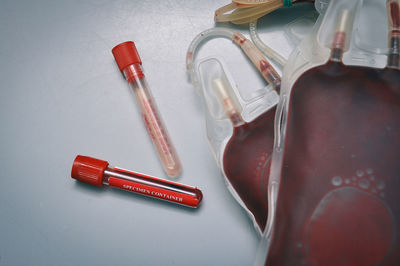 High angle view of blood bags with test tubes on table