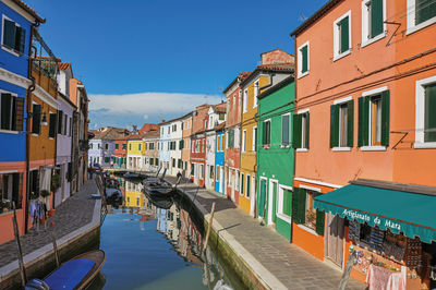 Canal amidst buildings against sky in city