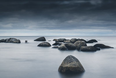 Rocks in sea against sky