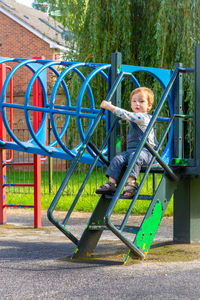 Portrait of smiling boy on slide at playground
