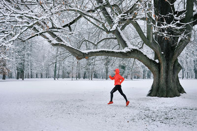 Running woman, girl runner on snow in park winter day. run, sport concept, leisure and freedom.