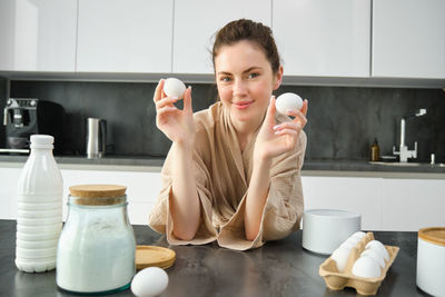 Portrait of young woman having breakfast at home