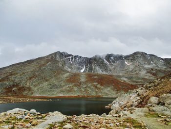 Scenic view of lake by mountain against sky