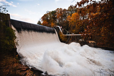 Scenic view of waterfall against sky during autumn