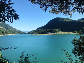 Scenic view of lake and mountains against blue sky