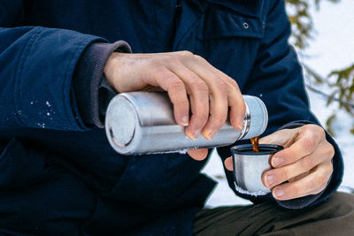 Midsection of man pouring drink