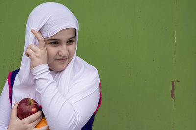 Portrait of teenage girl holding apple