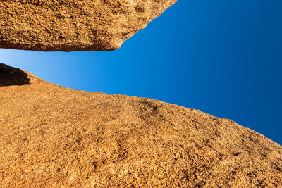 Low angle view of rock formation against clear blue sky