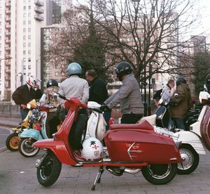 Rear view of people riding motorcycle on road