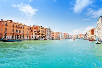 View of buildings by sea against sky