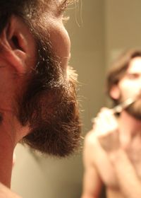 Close-up of man cutting beard