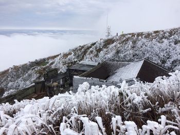 Houses on field against sky during winter