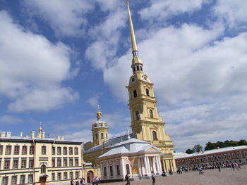People at historic building and cathedral in peter and paul fortress against sky