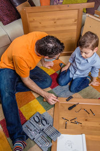 High angle view of father and son on table