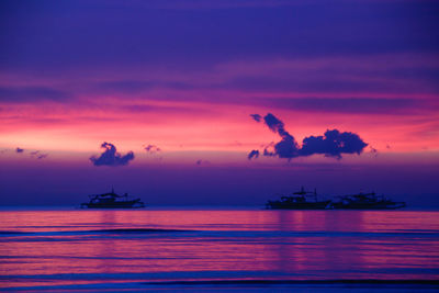 Silhouette boat sailing in sea against sky during sunset