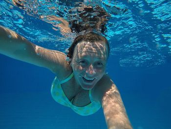 Portrait of woman swimming underwater