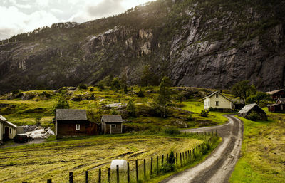 Houses by mountains against sky