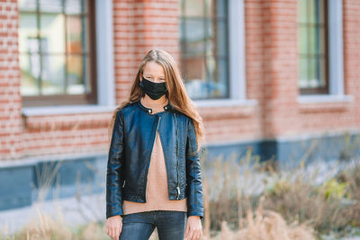 Girl wearing mask while standing outdoors