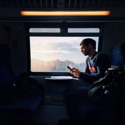 Woman taking selfie while sitting in train