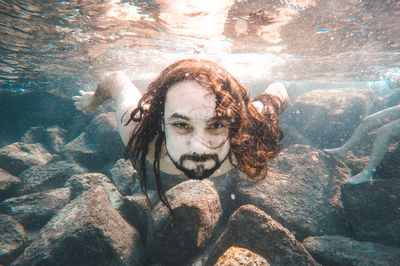 Portrait of young woman swimming underwater