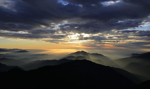 Scenic view of silhouette mountains against dramatic sky