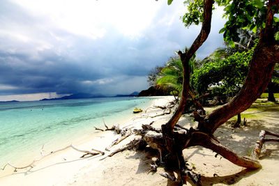 Scenic view of calm beach against cloudy sky