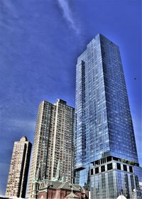 Low angle view of modern buildings against blue sky