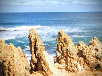 Scenic view of beach against cloudy sky