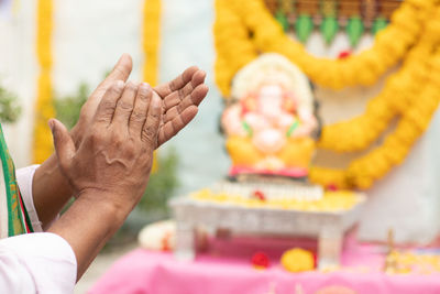 Close-up of hand holding cross in temple