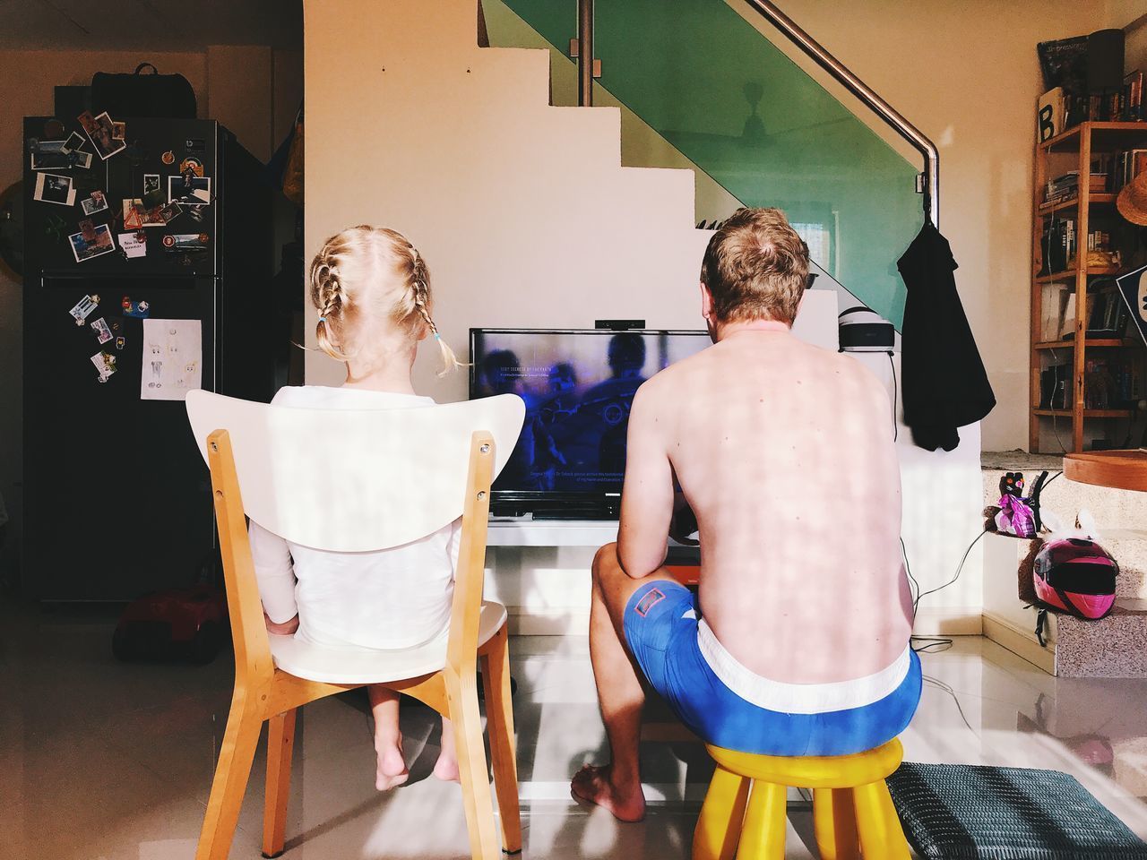 REAR VIEW OF FRIENDS SITTING ON TABLE