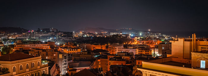 High angle view of illuminated cityscape against sky at night