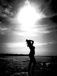 Sensuous woman posing on seashore against sky