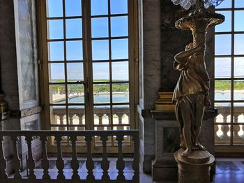 Statue seen through glass window of building