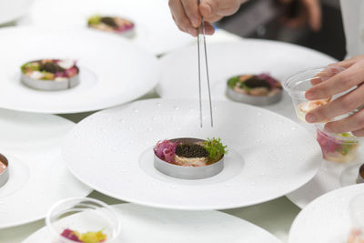 Close-up of hand holding salad served on table