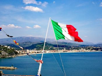 Scenic view of flag on sea against sky