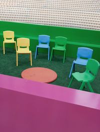 Empty chairs and table against wall