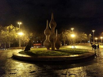 Statue of illuminated street light at night